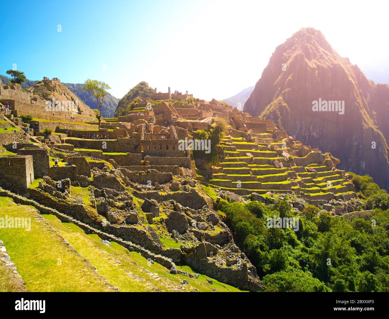 Antica città Inca di Machu Picchu illuminata dal sole. Rovine di Incan Lost città nella giungla peruviana. Sito patrimonio dell'umanità dell'UNESCO, Perù, Sud America. Foto Stock