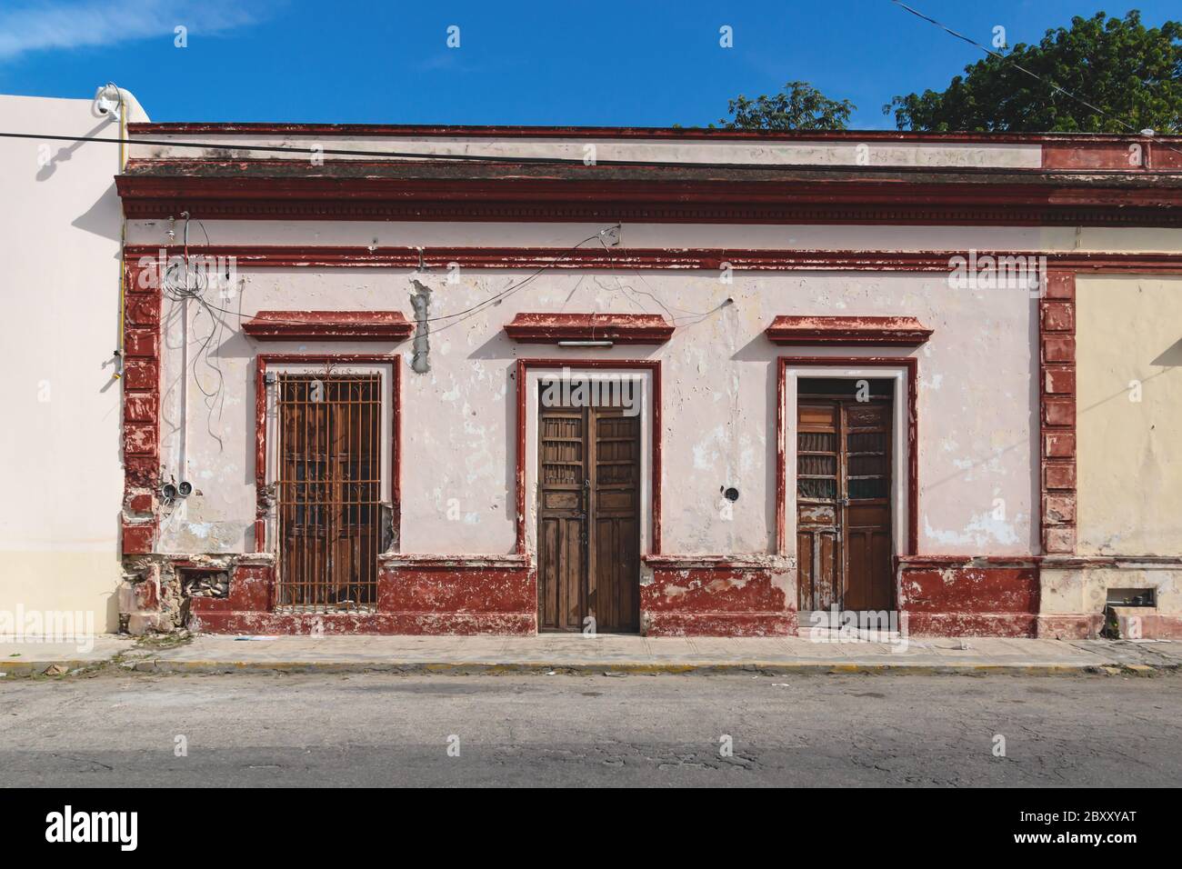 Facciata di tipico edificio coloniale abbandonato messicano con porte in legno a Merida, Yucatan, Messico Foto Stock