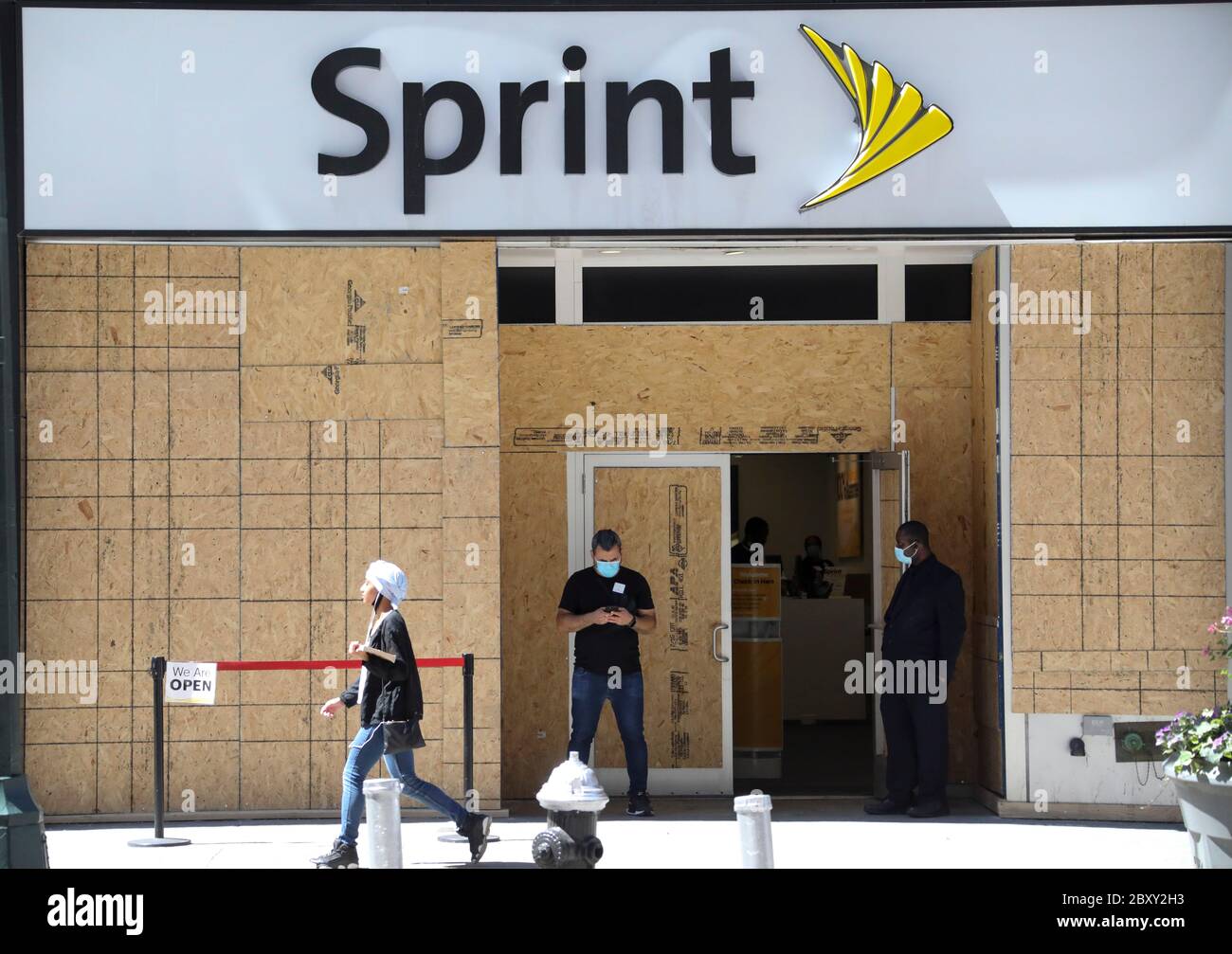 New York, Stati Uniti. 8 Giugno 2020. Un membro dello staff attende i clienti al di fuori di un negozio Sprint a Manhattan, New York, Stati Uniti, l'8 giugno 2020. Dopo quasi tre mesi di blocco, New York City è entrata nella prima fase di riapertura lunedì, 100 giorni da quando la città ha riportato il suo primo caso COVID-19. Credit: Wang Ying/Xinhua/Alamy Live News Foto Stock