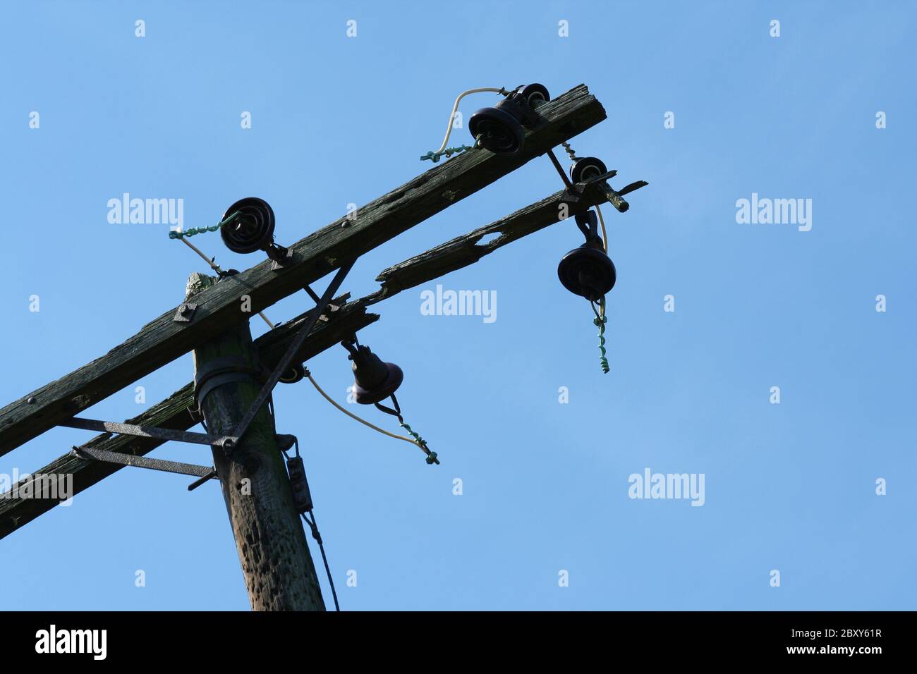 Un vecchio palo telefonico contro il cielo blu Foto Stock
