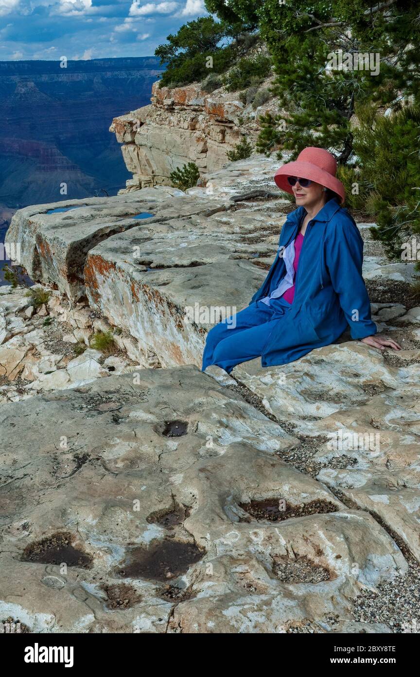 Donna che si rilassa su una scogliera nel Parco Nazionale del Grand Canyon Foto Stock