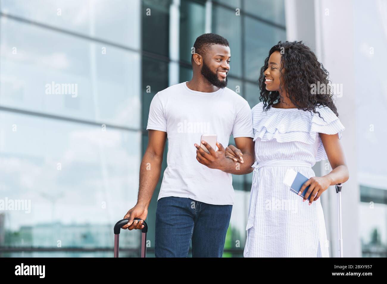 Felice coppia afro che va a viaggiare insieme, è arrivato all'aeroporto Foto Stock