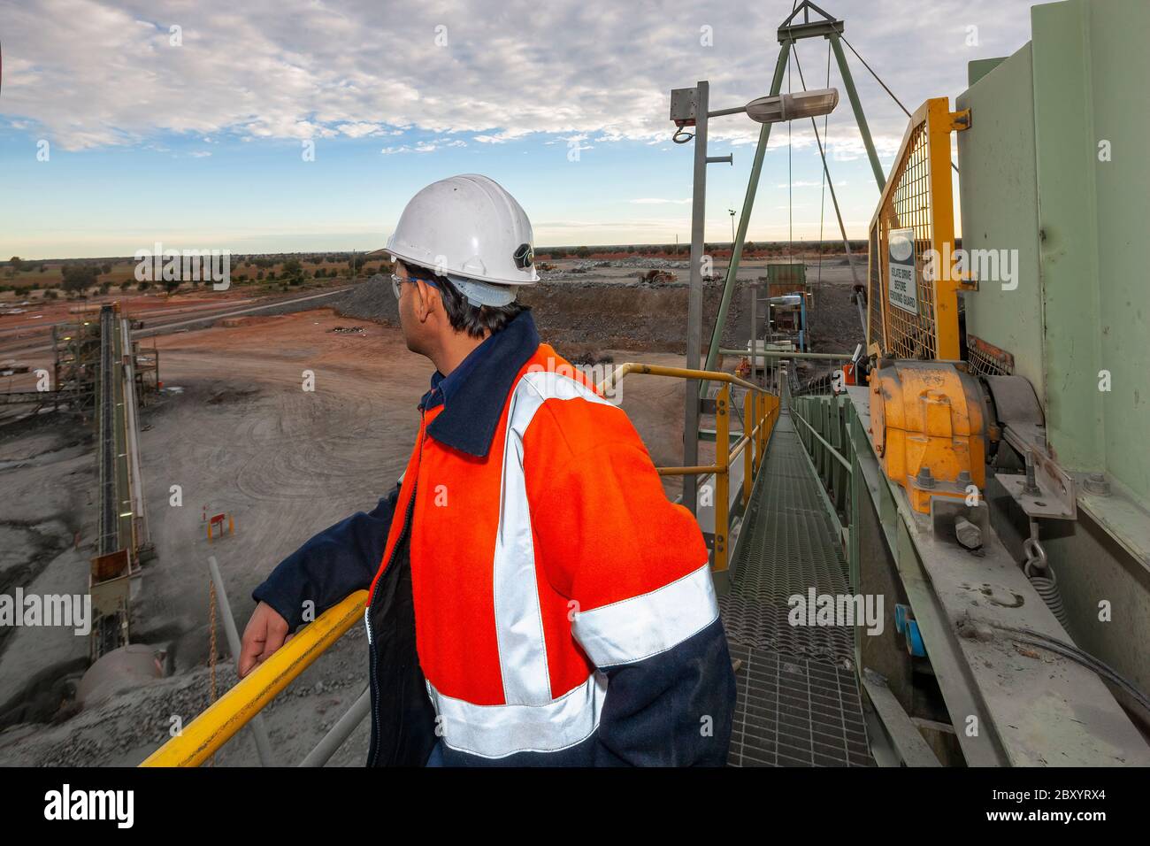 Nyngan Australia 20 Giugno 2012 : Miner in cima ad una piattaforma di frantumazione della roccia, effettua un'indagine sulla minehead nel NSW Australia Foto Stock