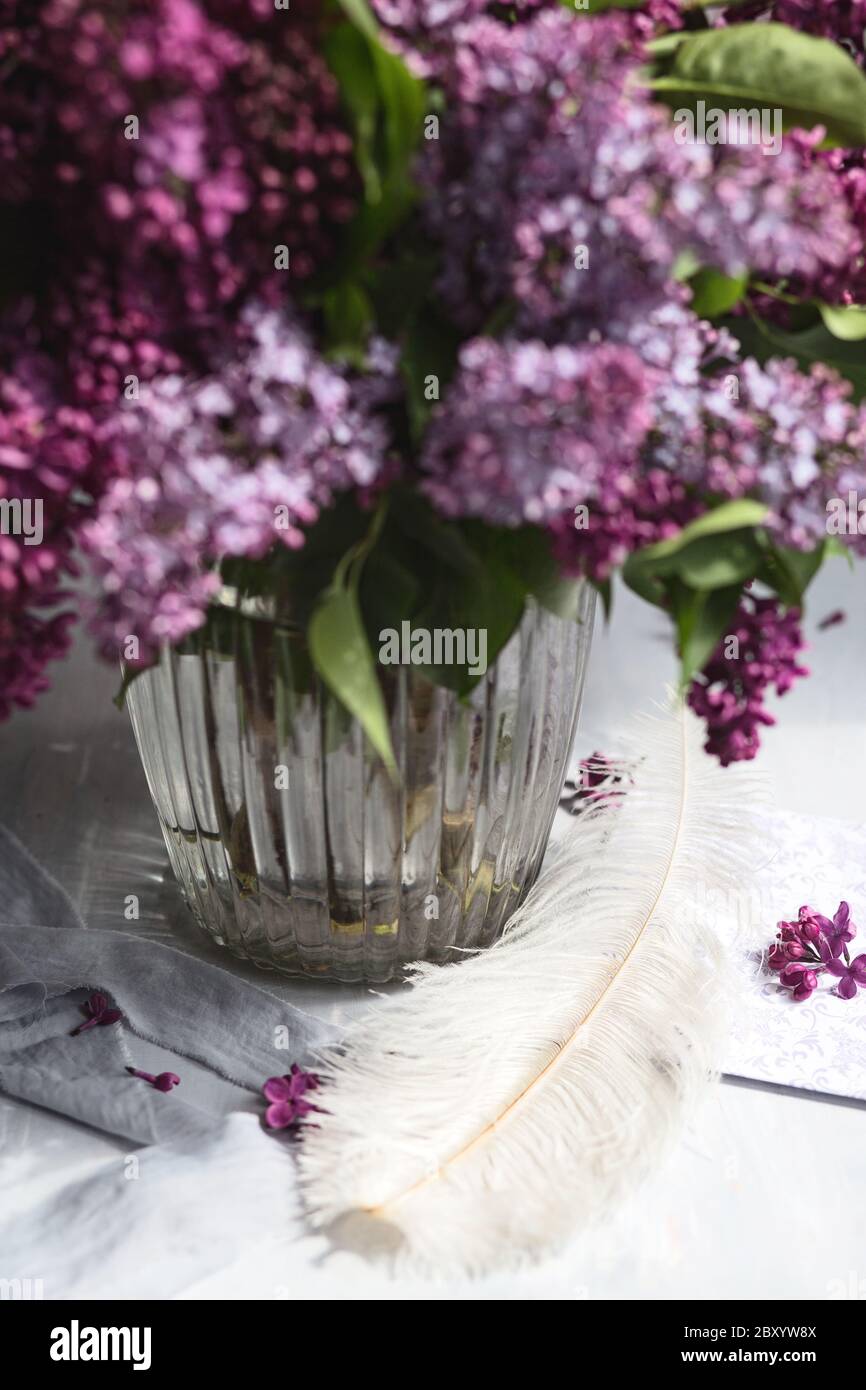 Bouquet di lilla viola in vaso di vetro. Ancora vita con rami fiorenti di lilla in vasi. Mock-up biglietto di auguri. Foto Stock