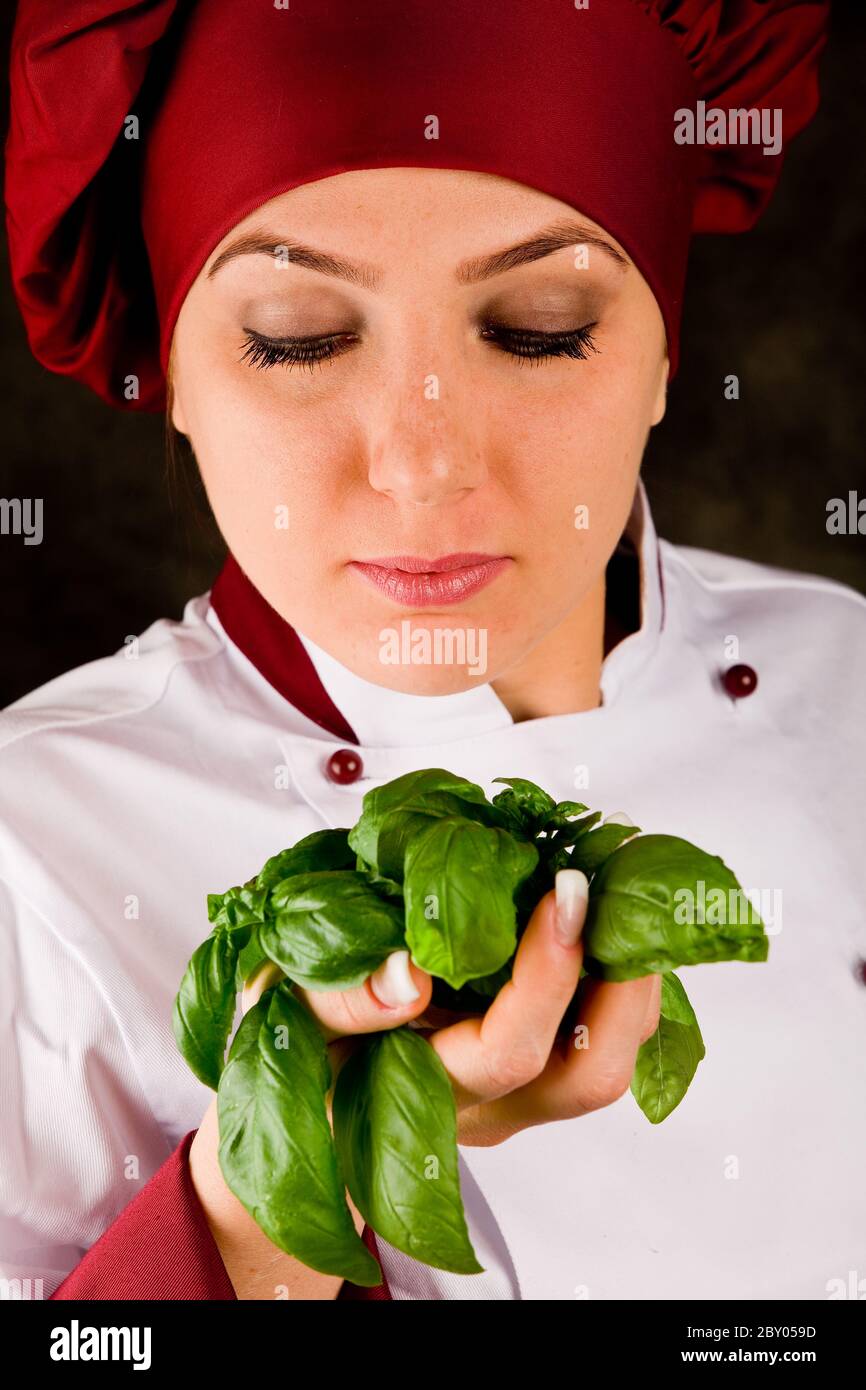 Lo chef controlla la qualità del basilico Foto Stock