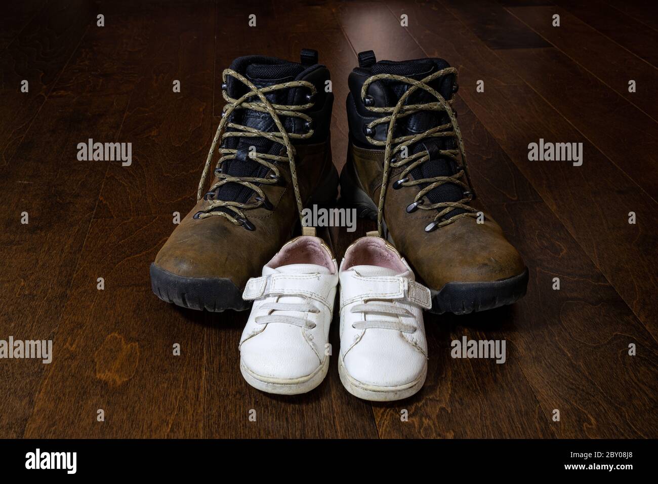 scarpe di padre e figlia su sfondo di legno Foto Stock