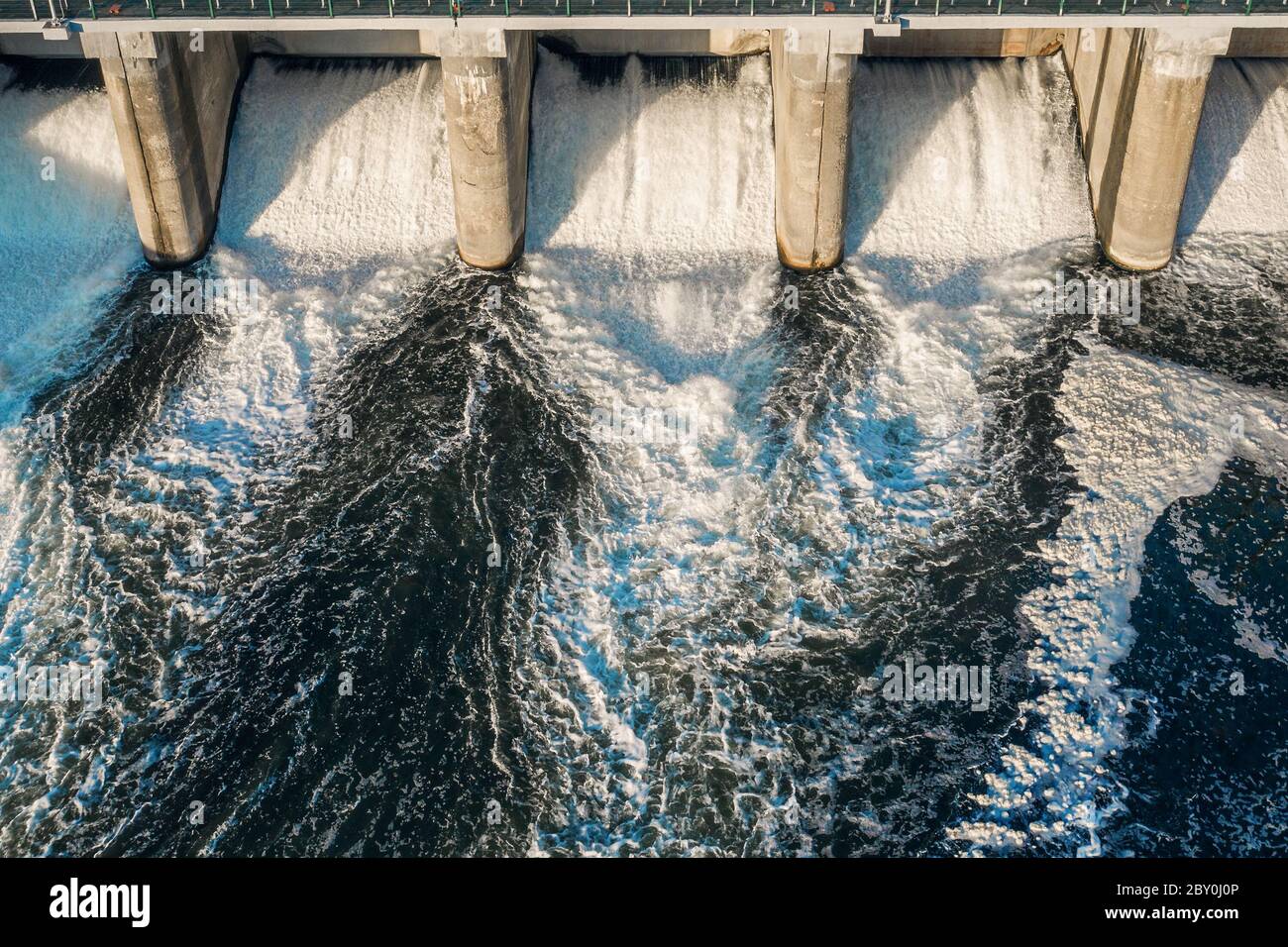 Diga idroelettrica con acqua che scorre attraverso il cancello, vista aerea dal drone. Foto Stock