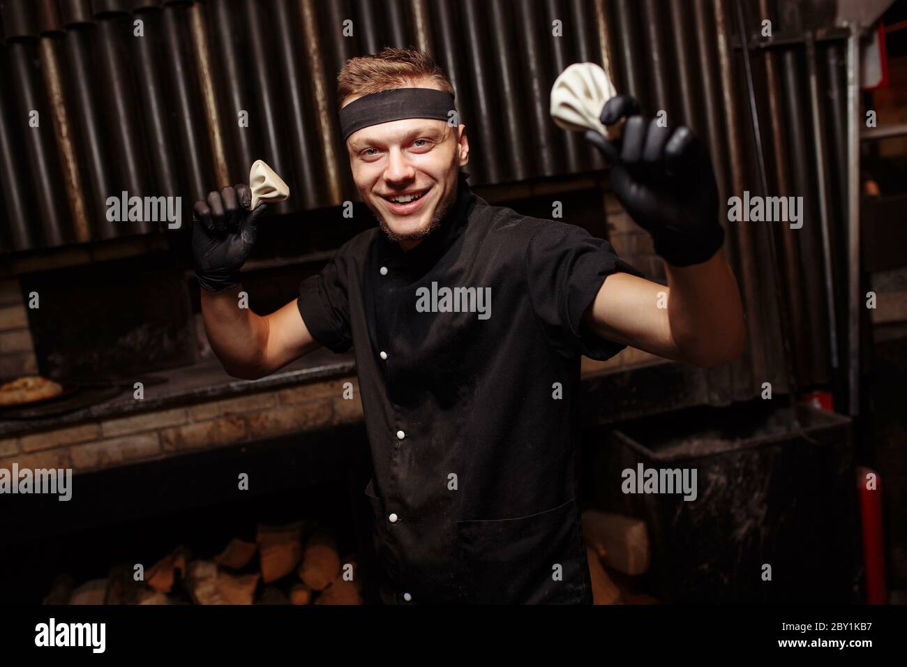 Chef allegro che propone un servizio di Khinkali. Cucina tradizionale georgiana. Cottura. Cucina. Concetto di cibo Foto Stock