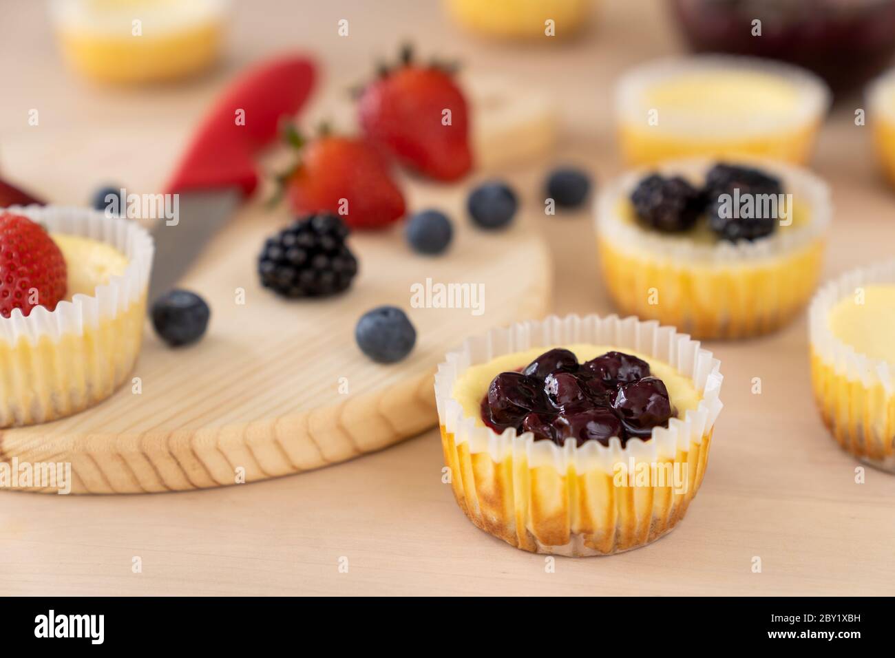 Mini cheesecake decorata con mirtillo, mora e fragola Foto Stock