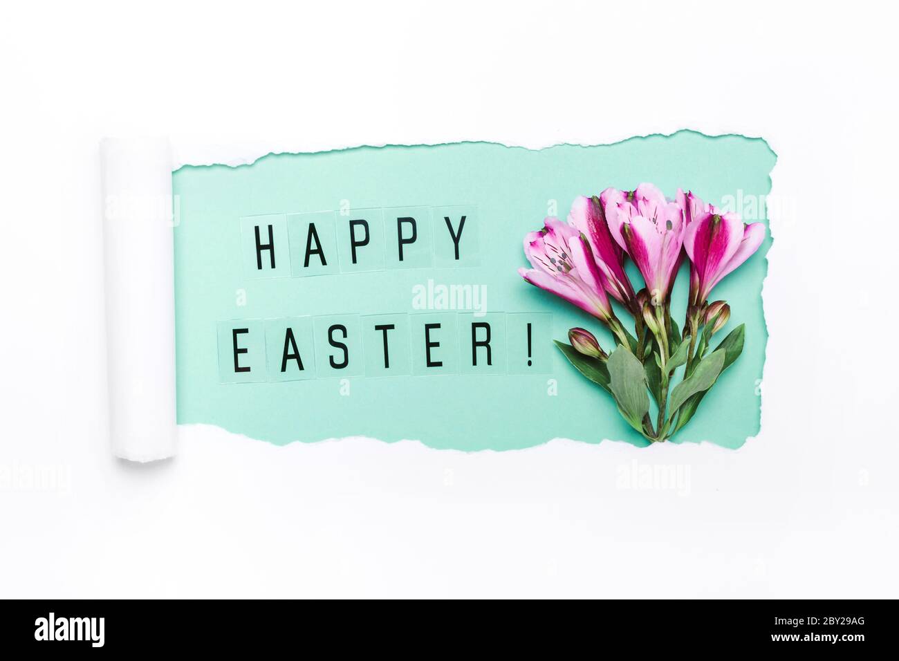 Layout creativo fatto di foro strappato, parole Pasqua felice e fiori viola. Felice biglietto di auguri pasquali. Foto Stock