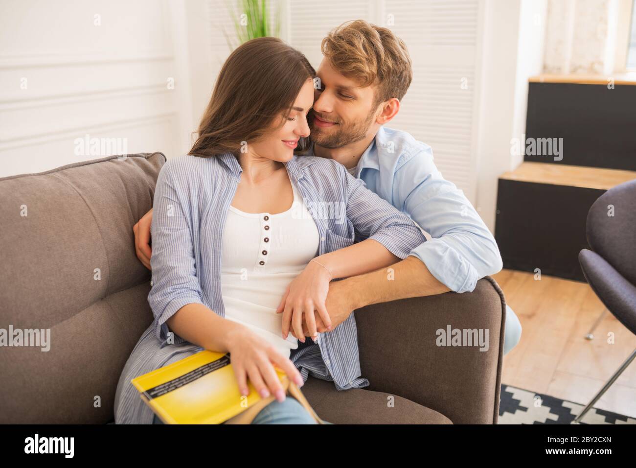 Giovane donna che studia prima dell'esame, suo marito la abbracciò Foto Stock