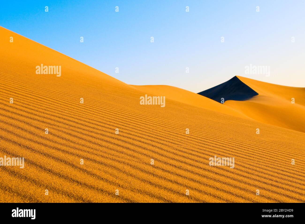 Dune di sabbia oltre il cielo blu Foto Stock