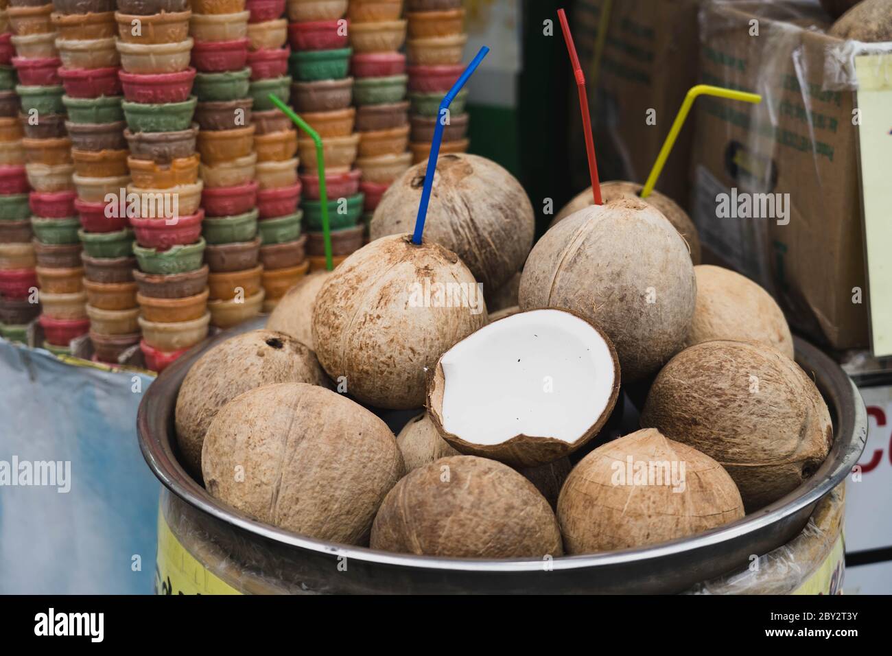 Rinfrescanti frutta estiva, acqua di cocco accatastata. Conchiglie di cocco tropicale bevono con paglia. Foto Stock