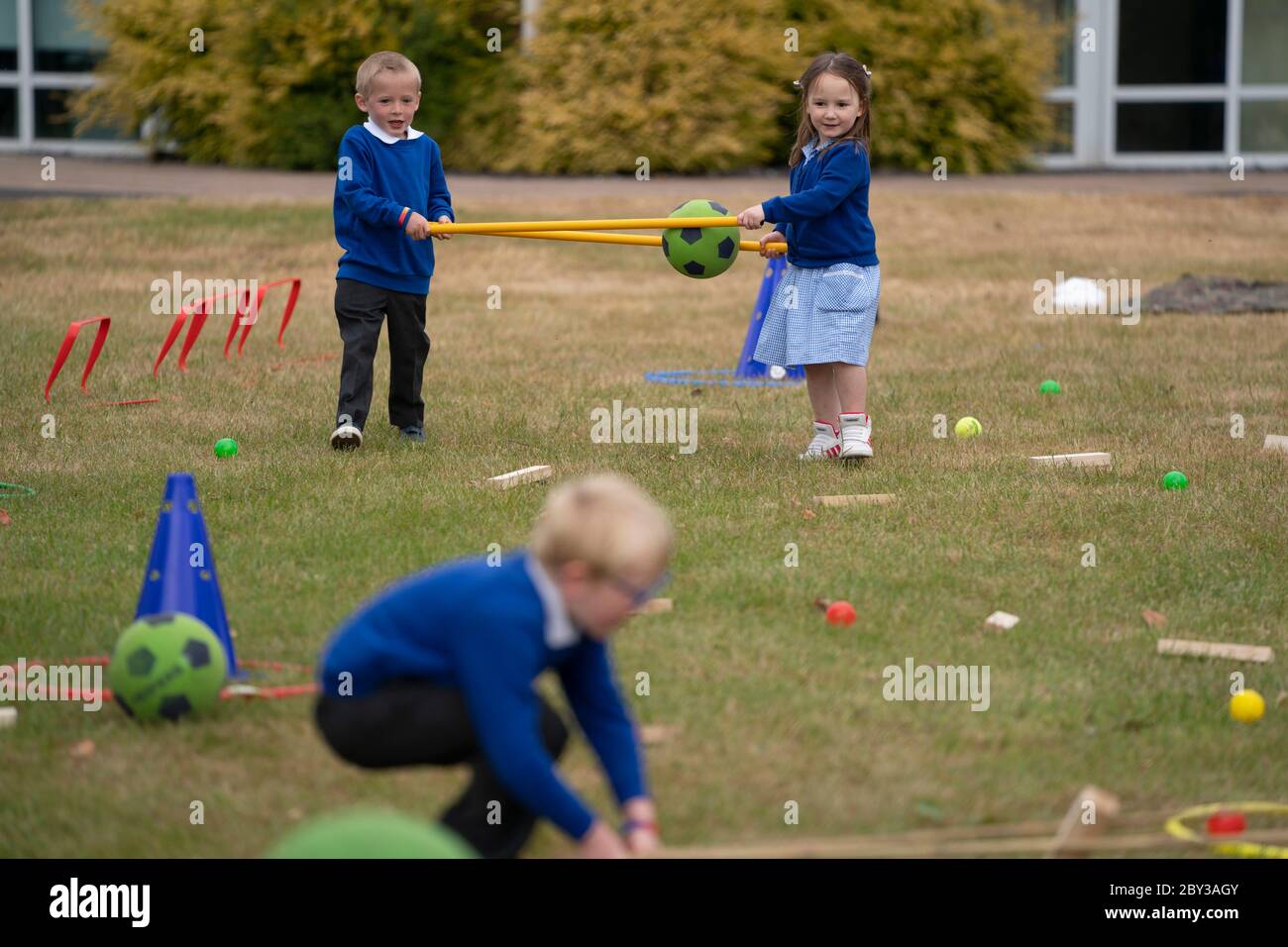 Staffordshire. 8 Giugno 2020. Gli studenti di accoglienza della Landywood Primary School usano bastoni per mantenere la distanza sociale mentre prendono parte ad un programma educativo del personaggio del Commando Joe a Staffordshire, Gran Bretagna, l'8 giugno 2020. Il programma di Commando Joe è un servizio di sviluppo e supporto educativo di grande personalità per le scuole di tutto il Regno Unito, che ispira gli studenti con competenze di team-building, carattere e resilienza. Aiuta gli studenti a far fronte alla reintegrazione nell'ambiente scolastico. Credit: Jon Super/Xinhua/Alamy Live News Foto Stock