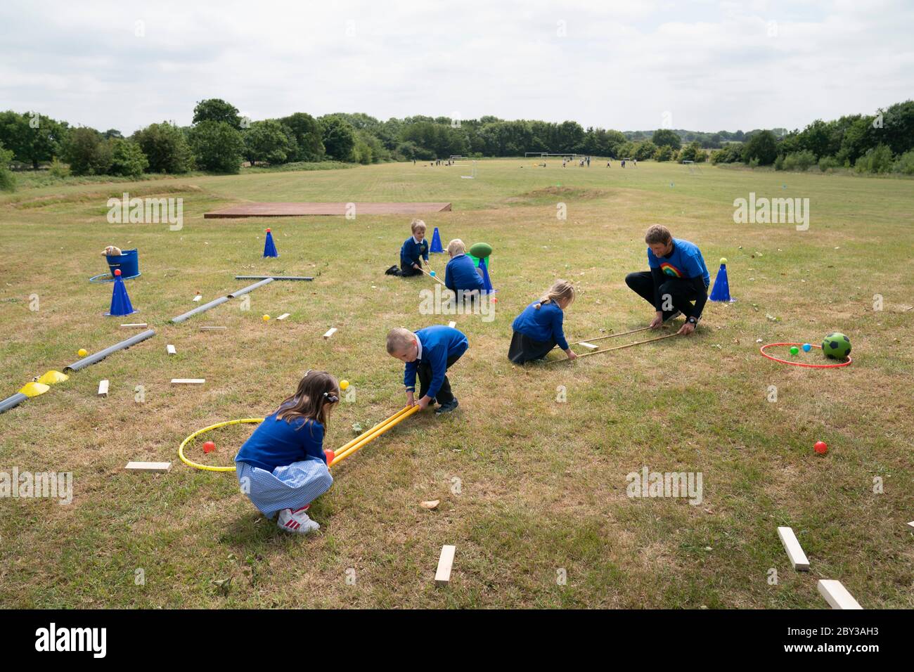 Staffordshire. 8 Giugno 2020. Gli studenti di accoglienza della Landywood Primary School usano bastoni per mantenere la distanza sociale mentre prendono parte ad un programma educativo del personaggio del Commando Joe a Staffordshire, Gran Bretagna, l'8 giugno 2020. Il programma di Commando Joe è un servizio di sviluppo e supporto educativo di grande personalità per le scuole di tutto il Regno Unito, che ispira gli studenti con competenze di team-building, carattere e resilienza. Aiuta gli studenti a far fronte alla reintegrazione nell'ambiente scolastico. Credit: Jon Super/Xinhua/Alamy Live News Foto Stock