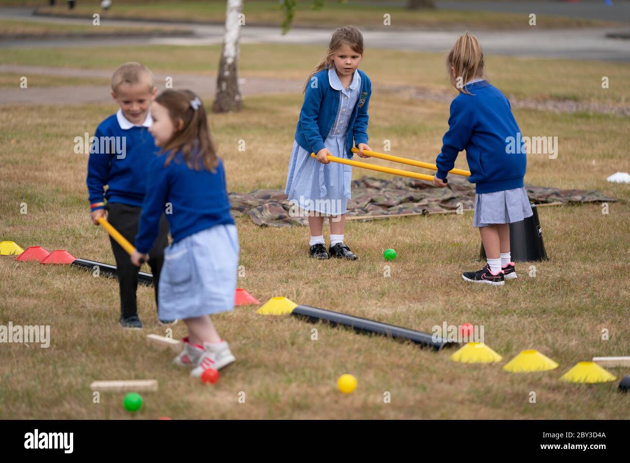 Staffordshire. 8 Giugno 2020. Gli studenti di accoglienza della Landywood Primary School usano bastoni per mantenere la distanza sociale mentre prendono parte ad un programma educativo del personaggio del Commando Joe a Staffordshire, Gran Bretagna, l'8 giugno 2020. Il programma di Commando Joe è un servizio di sviluppo e supporto educativo di grande personalità per le scuole di tutto il Regno Unito, che ispira gli studenti con competenze di team-building, carattere e resilienza. Aiuta gli studenti a far fronte alla reintegrazione nell'ambiente scolastico. Credit: Jon Super/Xinhua/Alamy Live News Foto Stock