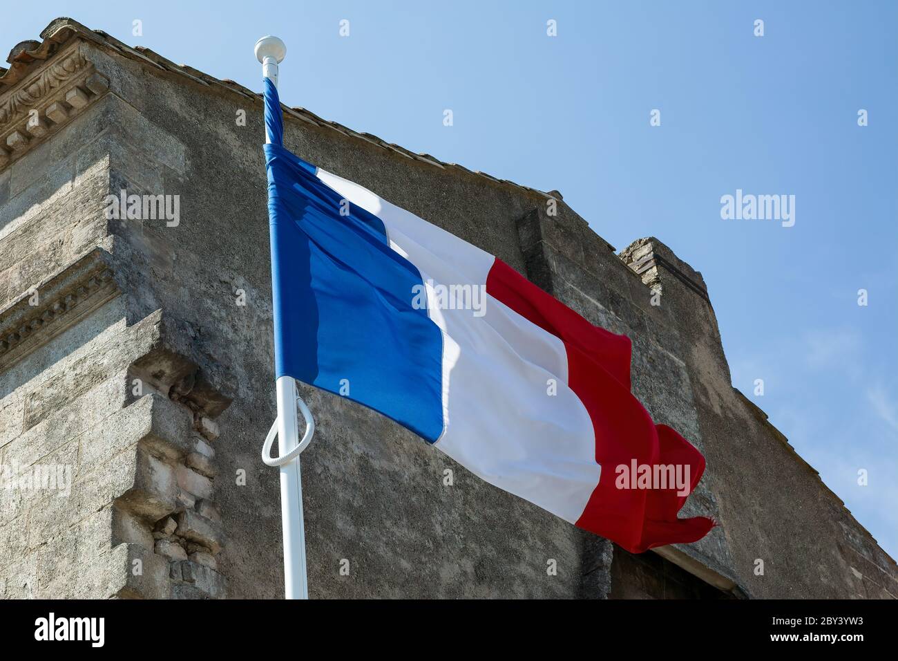 Les Baux de Provence Francia 14 luglio 2015 : bandiera francese che batte in una piccola città della Provenza, Francia Foto Stock
