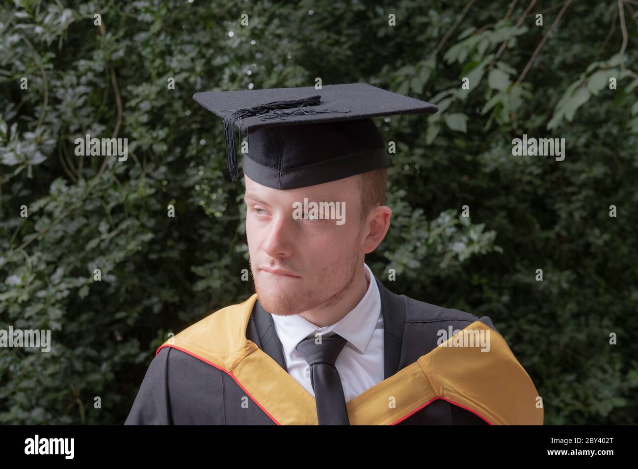Studente laureato in abbigliamento universitario in attesa di ricevere la laurea da una delle principali università del Regno Unito. Foto Stock