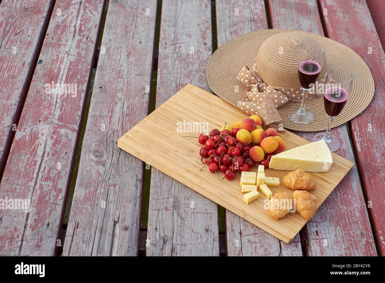 Due bicchieri di vino rosso, serviti all'aperto con frutta. Foto Stock