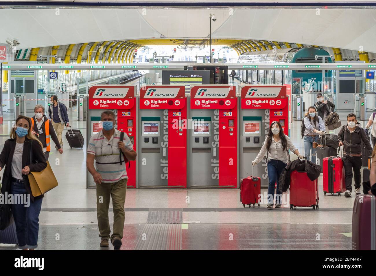 Passeggeri non identificati con maschere mediche camminano verso il terminal di partenza 3 dell'aeroporto di Roma Fiumicino, Roma, Italia Foto Stock