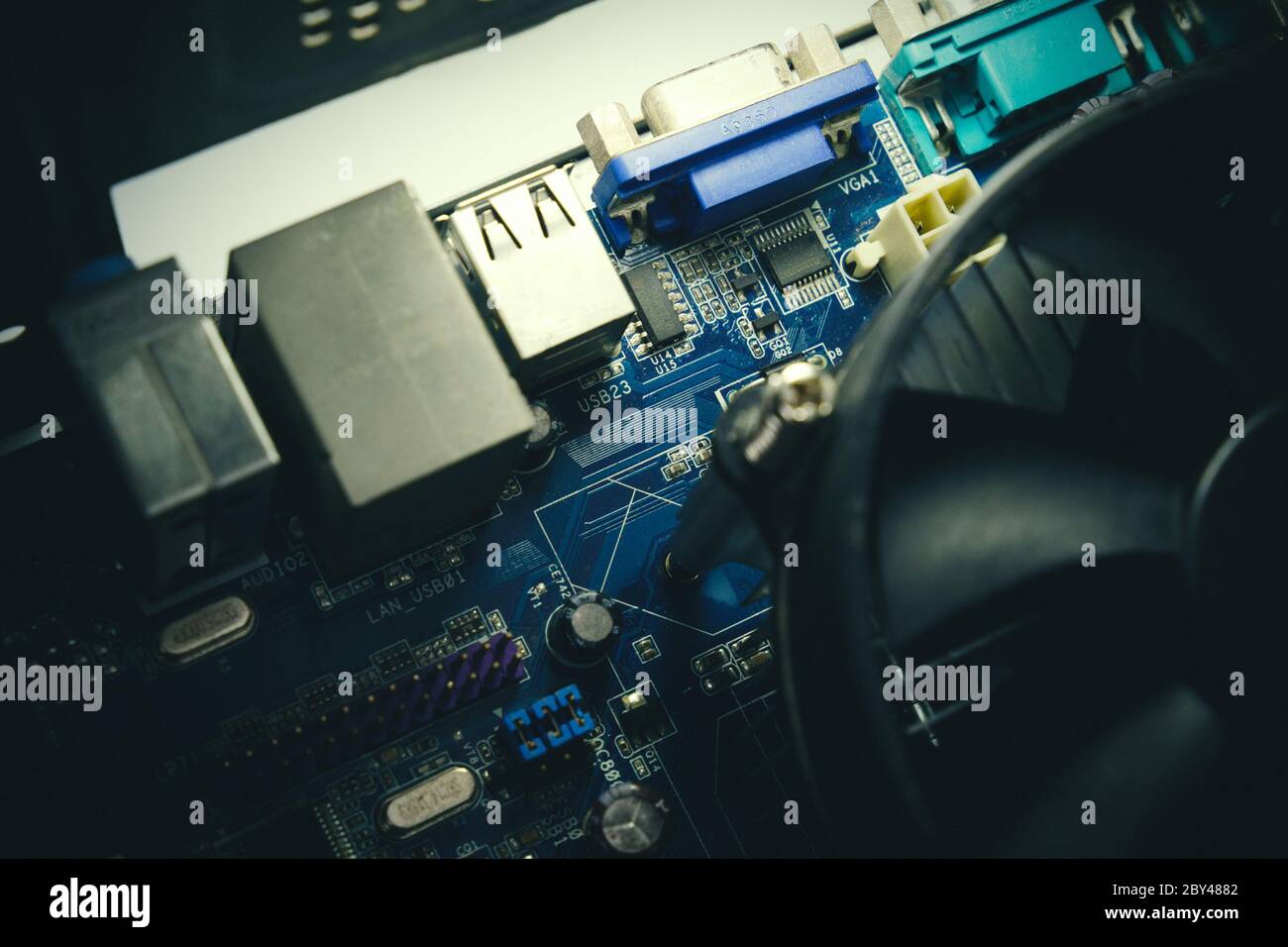 Componenti sulla scheda a circuito stampato del PC. Chip, ventola, condensatore e connettori sulla scheda madre di un personal computer. Foto interna per sfondo Foto Stock