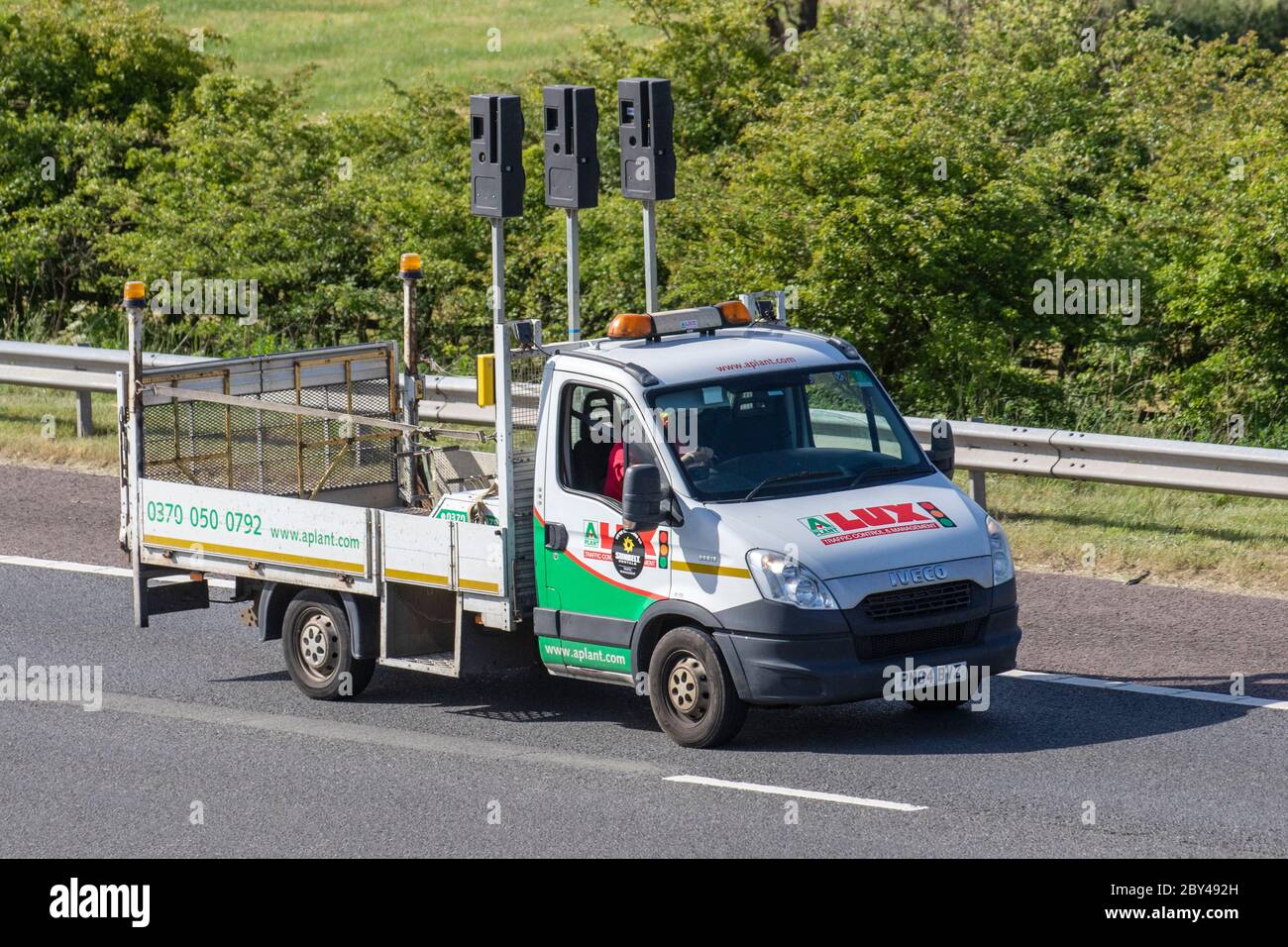 A-Plant controllo e gestione del traffico, fornitore di segnali di traffico portatili di soluzioni di gestione temporanea del traffico, noleggio di flotte semafori temporanei. Carrelli per consegna a Dropside, camion, trasporto, camion, cargo cargo cargo, Iveco, HGV per l'industria europea dei trasporti commerciali, M61 a Manchester, Regno Unito Foto Stock