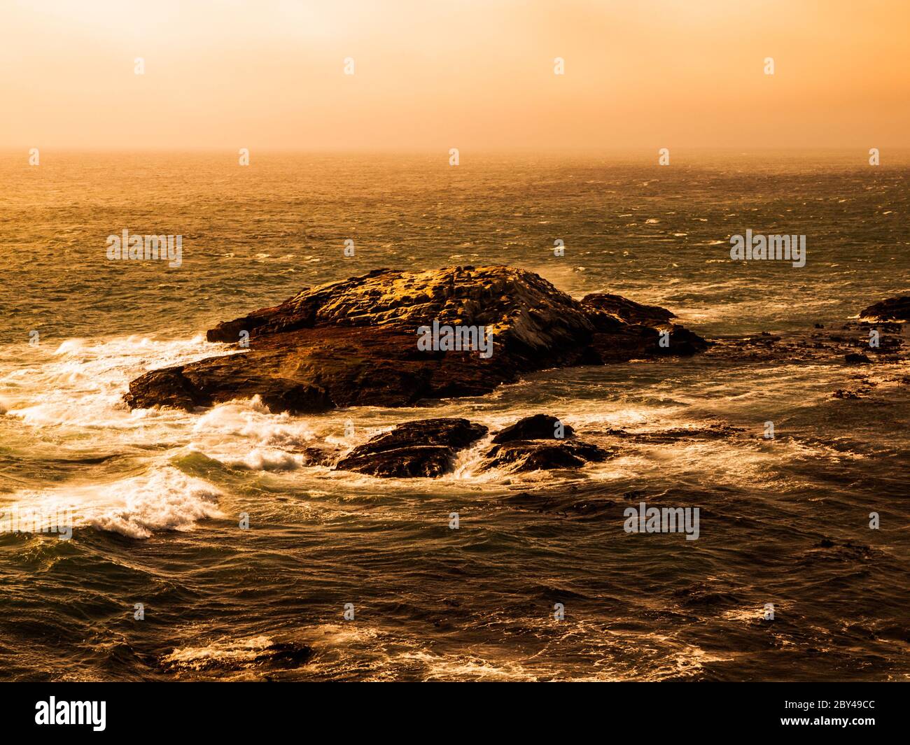 Onde di mare tempestose che si infrangono sulle rocce della costa. Tempo di sera tempestoso sull'oceano. Foto Stock