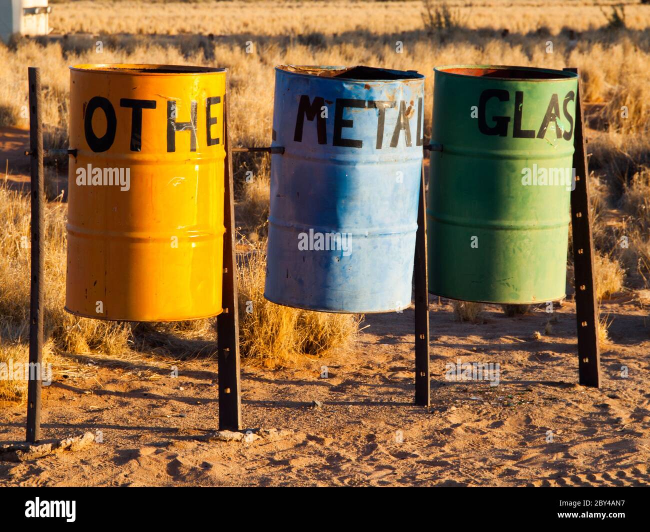 Tre contenitori colorati per il riciclaggio di metallo, vetro e altri rifiuti nella natura. Barili di stagno sul campeggio per la separazione dei rifiuti. Foto Stock