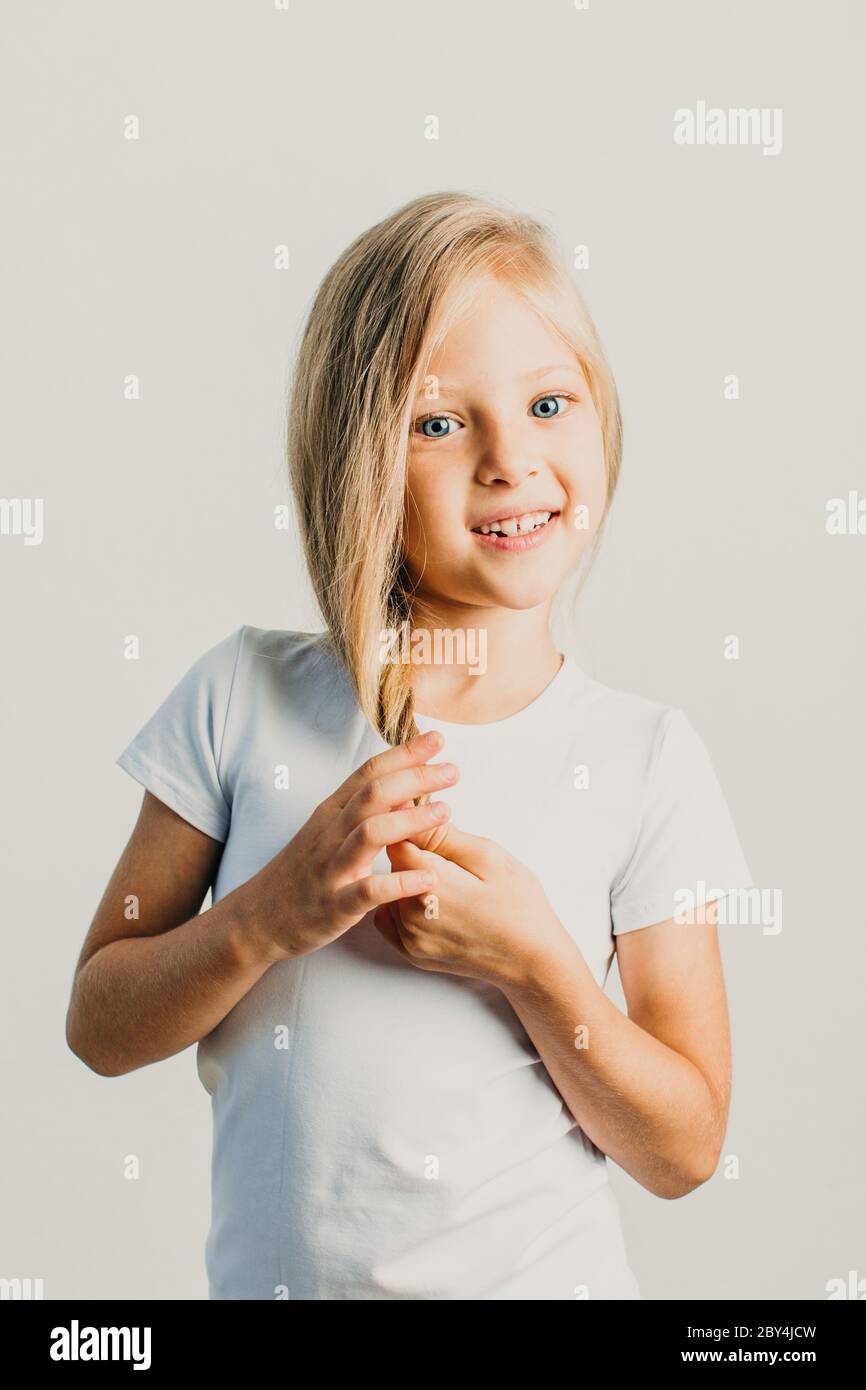 Bella bambina bionda che posa in studio Foto Stock