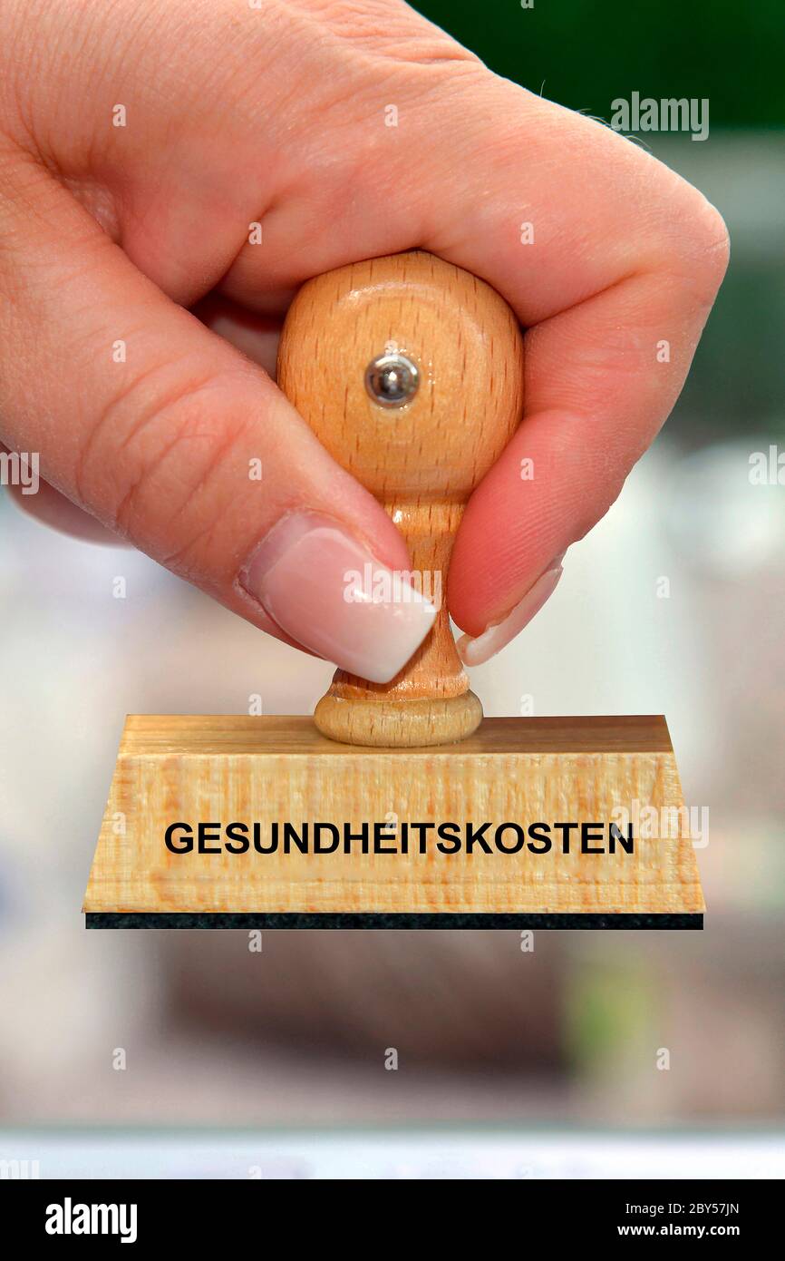 Mano con timbro scritta Gesundheitskosten, costi sanitari, Germania Foto Stock