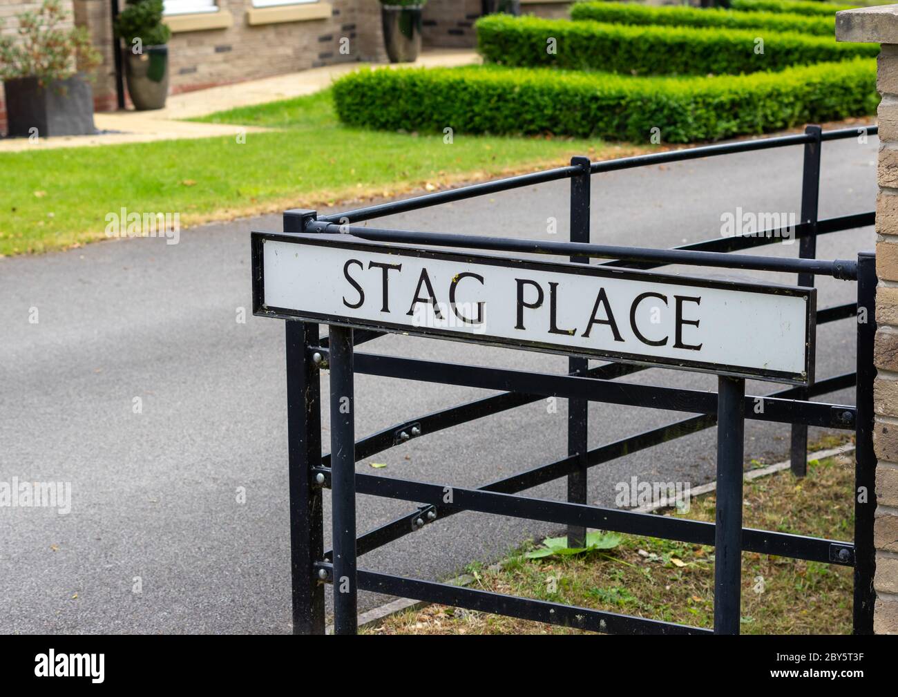 Un cartello stradale britannico per una strada chiamata Stag Place montato su pali, nero con sfondo bianco Foto Stock