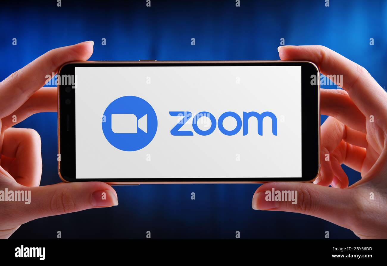 POZNAN, POL - 21 MAGGIO 2020: Smartphone con mani in mano che mostra il logo di Zoom, videotelefonia e servizi di chat online attraverso un peer-to-pe basato su cloud Foto Stock