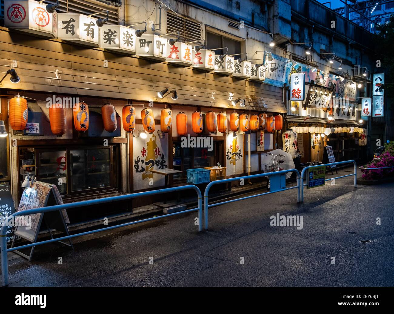 Piccoli ristoranti e pub in stile giapponese o izakaya nella strada dietro il viale del quartiere di Yurakucho, Tokyo, Giappone di notte. Foto Stock