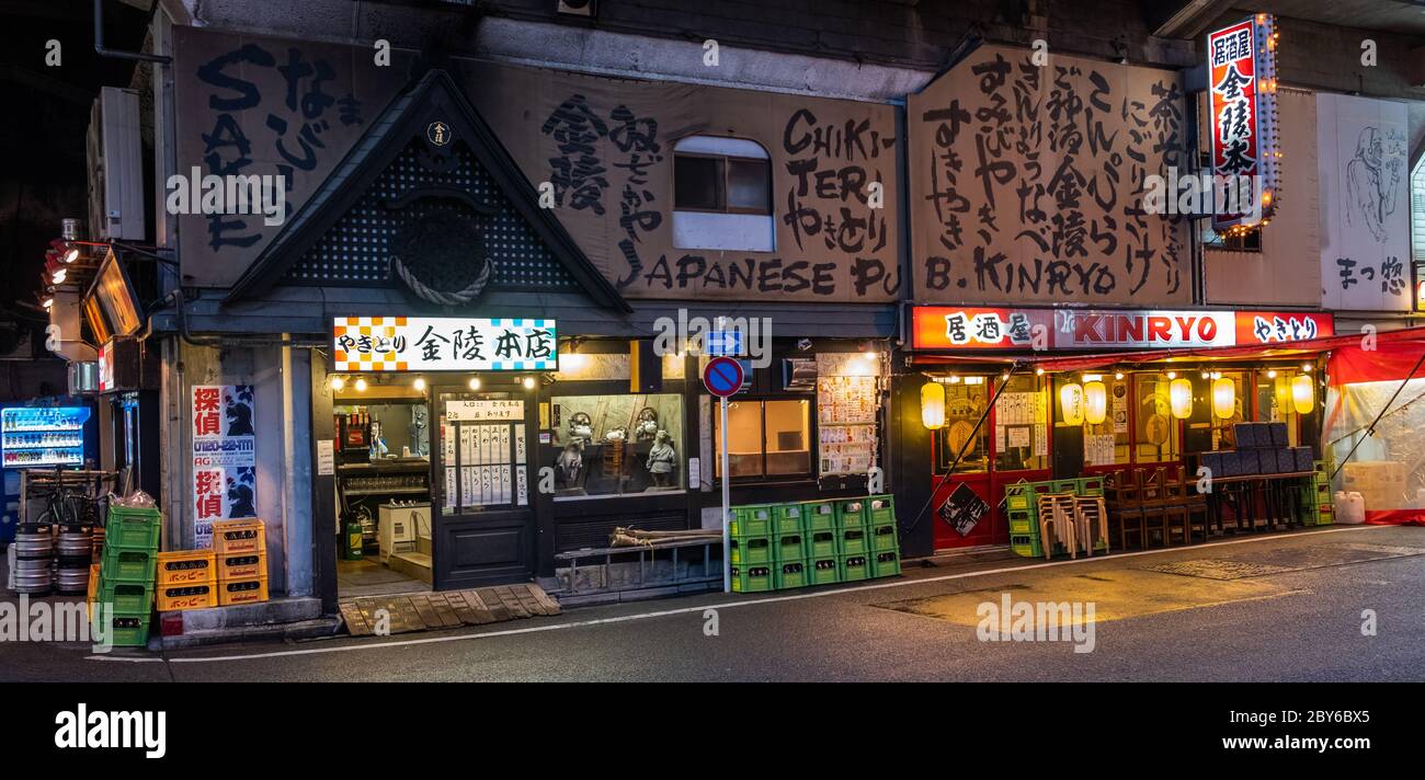 Piccoli ristoranti e pub in stile giapponese o izakaya nella strada dietro il viale del quartiere di Yurakucho, Tokyo, Giappone di notte. Foto Stock