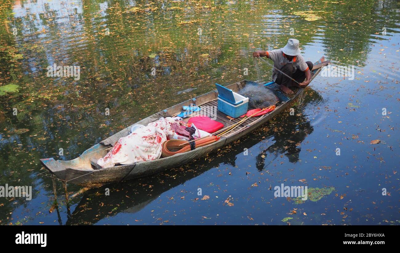 cambogia siem raccogliere l'uomo fiume in barca pesca con rete gettata Foto Stock
