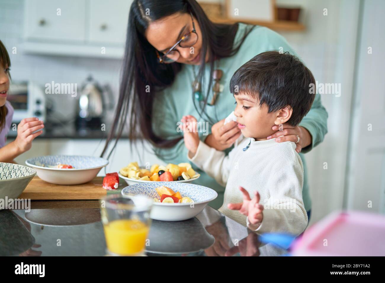 Famiglia che mangia frutta in cucina Foto Stock