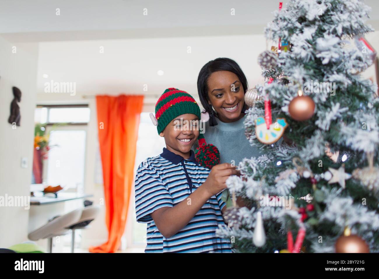 Felice madre e figlio decorare albero di Natale Foto Stock
