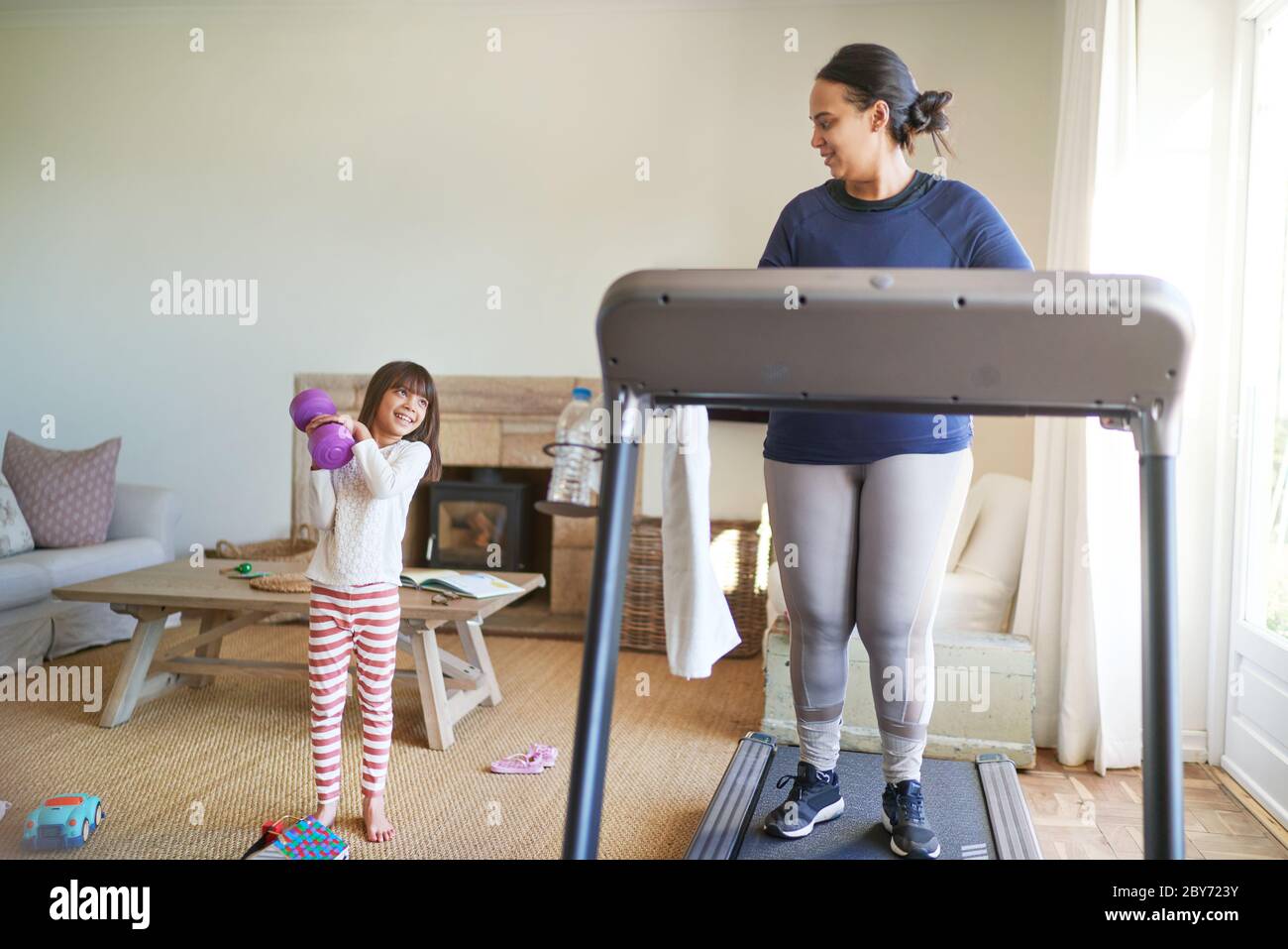 Madre e figlia che si esercitano in soggiorno Foto Stock