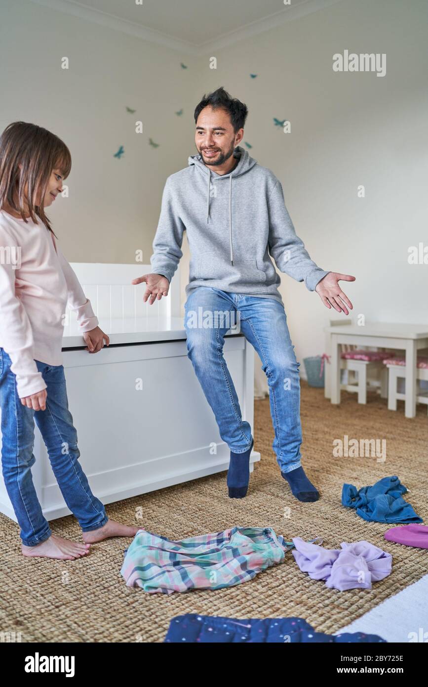 Padre aiutare figlia pulire camera da letto Foto Stock