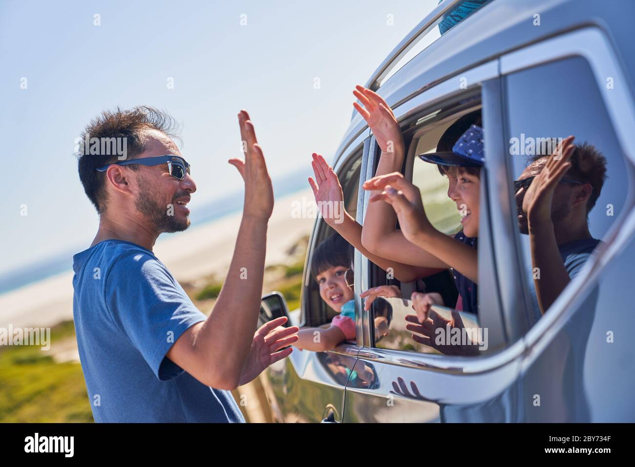 Padre bambini in auto in spiaggia soleggiato Foto Stock