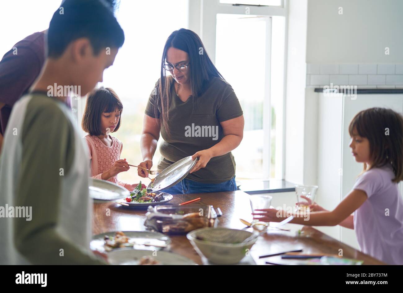 Famiglia pulizia cibo e piatti dal tavolo da pranzo Foto Stock