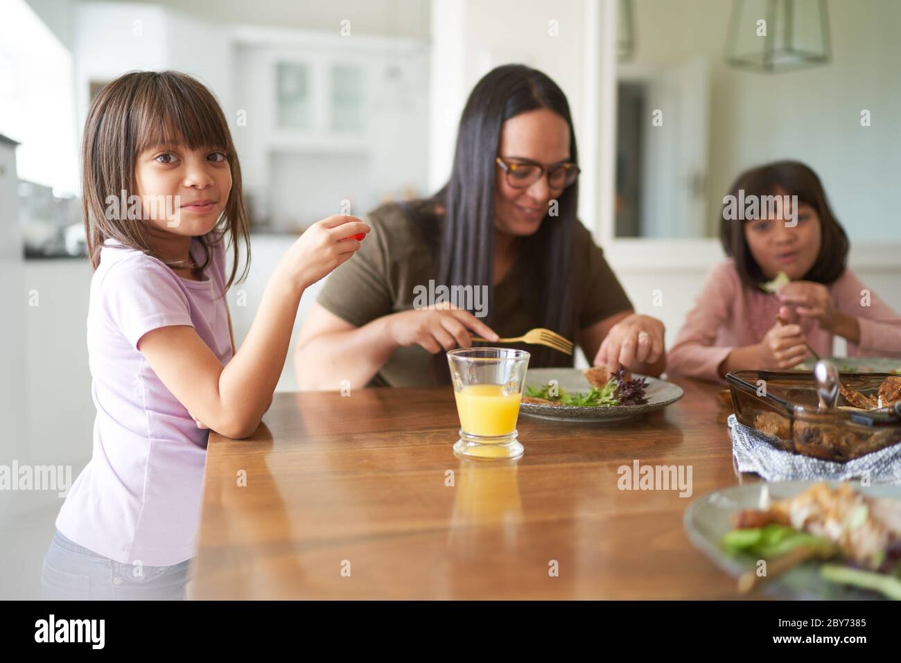 Madre e figlie mangiano il pranzo al tavolo Foto Stock