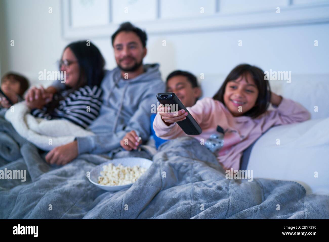 Famiglia rilassante sul divano e guardare la TV con pop corn Foto Stock