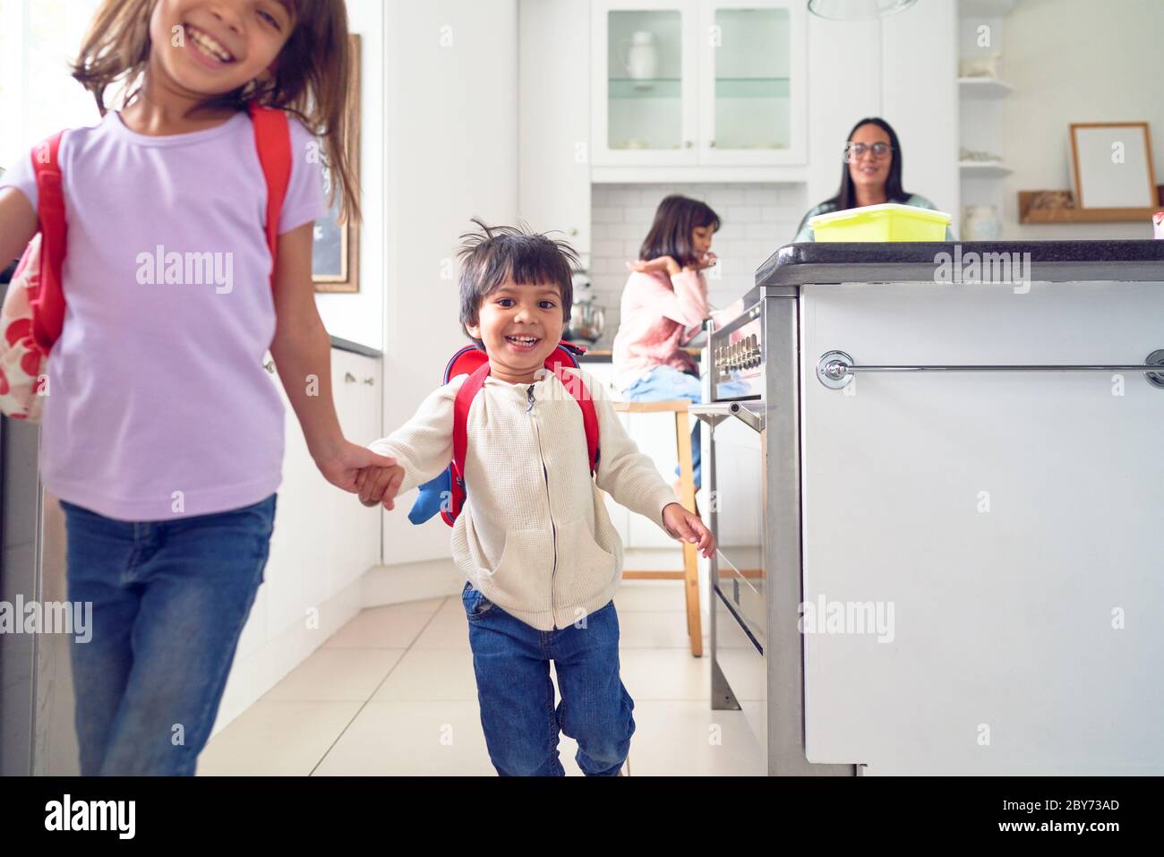 Felice fratello e sorella che tengono le mani e che lasciano per la scuola Foto Stock