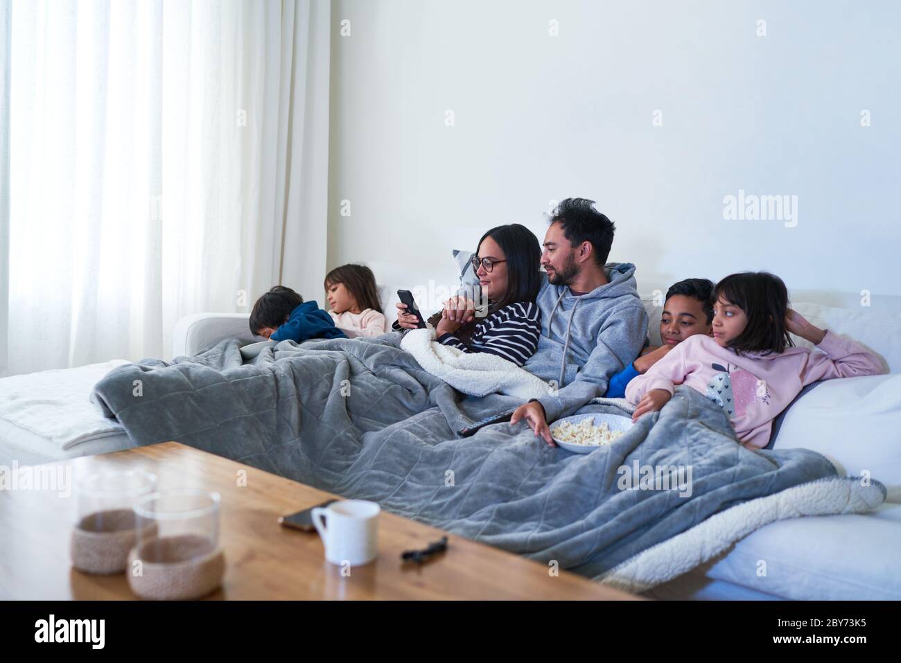 Famiglia rilassante e guardare film sul divano del soggiorno Foto Stock