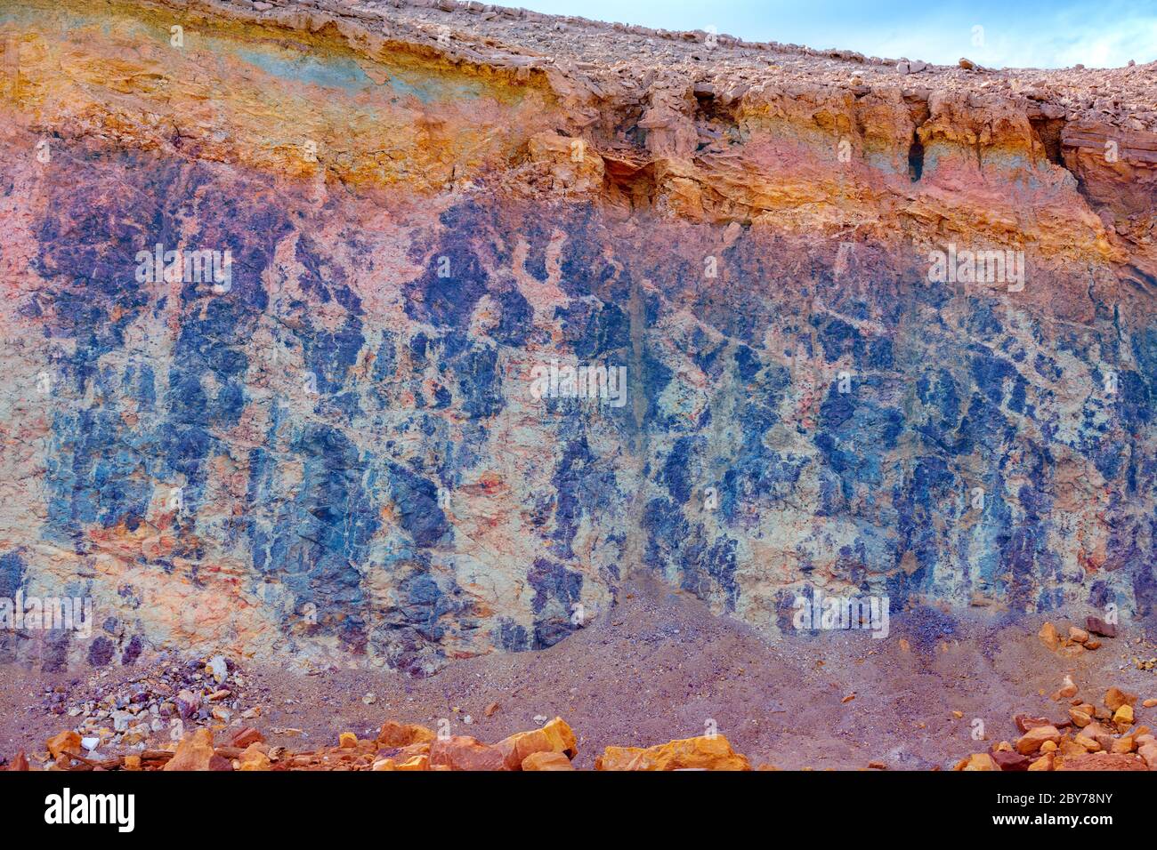 Struttura astratta in arenaria, bande colorate, sfondo naturale. Cratere di Makhtesh Ramon nel parco nazionale nel deserto di Negev, Israele Foto Stock