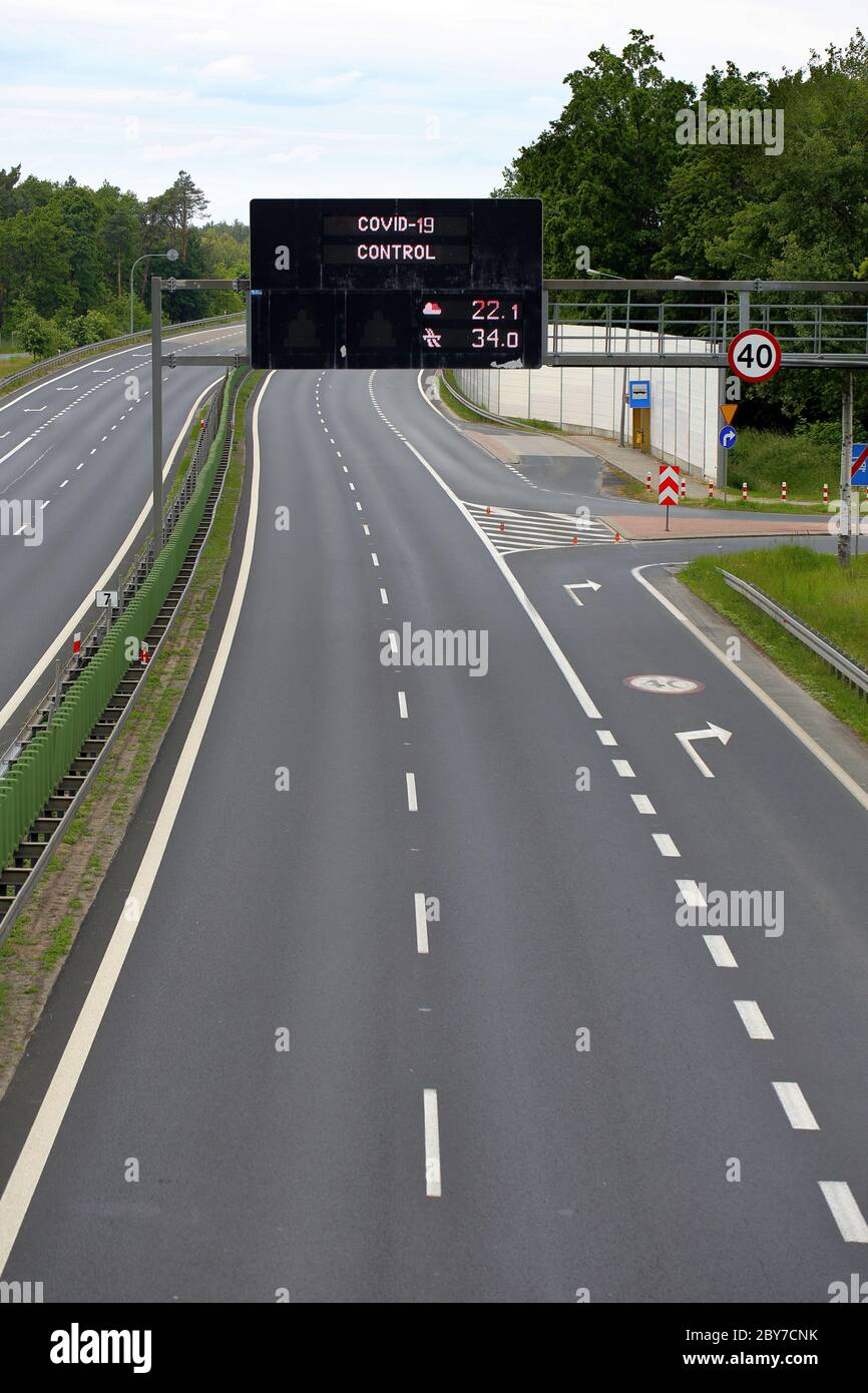 Autostrada vuota e scheda informativa con iscrizione di controllo covid-19 Foto Stock