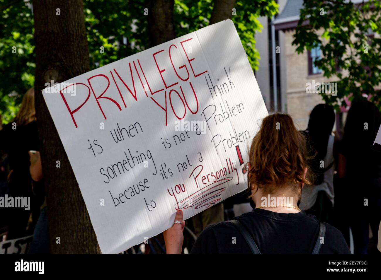 Una donna ha un segno di privilegio bianco mentre migliaia si riuniscono nel centro di Ottawa, Canada, per protestare contro la violenza e il razzismo della polizia. Foto Stock