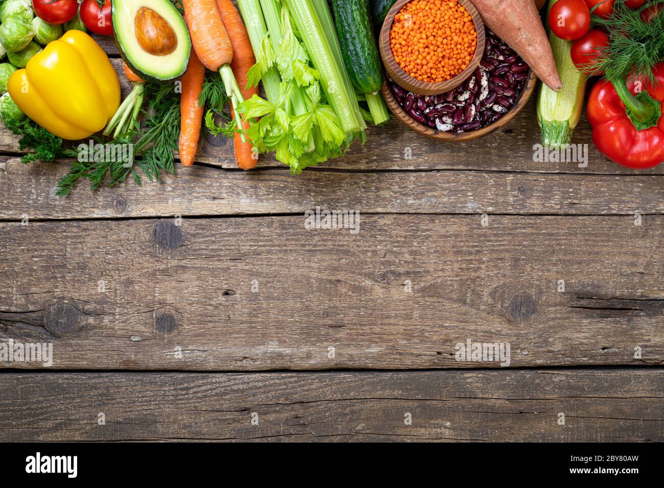 Sfondo cibo sano. Verdure fresche, frutta, fagioli e lenticchie su tavola di legno. Cibo vegetariano. Cibo sano, dieta, vegan e mangiare sano co Foto Stock