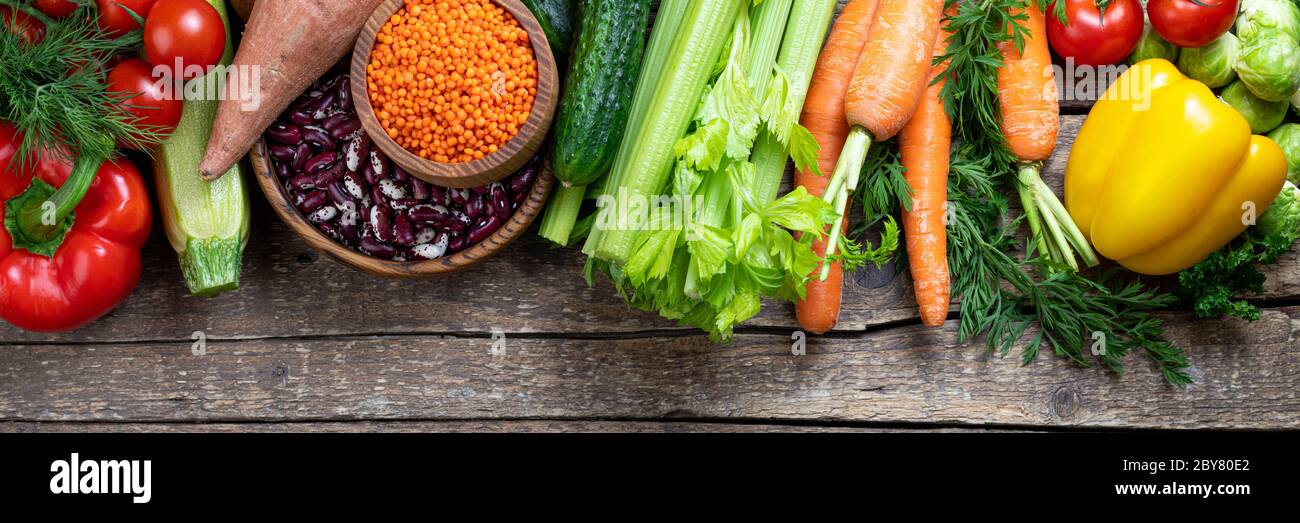 Sfondo alimentazione sana. Verdure fresche, frutta, fagioli e lenticchie su tavola di legno. Cibo vegetariano. Cibo sano, dieta e concetto di alimentazione sana Foto Stock